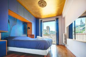 een slaapkamer met een blauw bed en een balkon bij Un balcon sur Notre Dame in Marseille