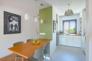 een keuken en eetkamer met een houten tafel en stoelen bij Un balcon sur Notre Dame in Marseille