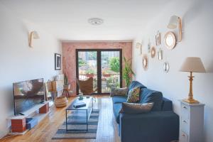 a living room with a blue couch and a tv at Un balcon sur Notre Dame in Marseille