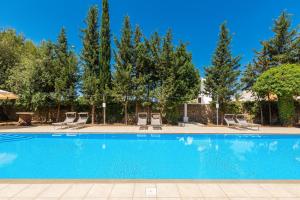 einen Pool mit Liegestühlen und Bäumen in der Unterkunft B&B Luxury da Salvatore in Presicce