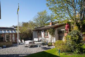 uma casa com um pátio de cascalho ao lado de uma casa em Flodhästens Husrum & Frukost em Varberg