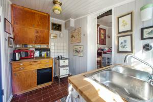 a kitchen with a large sink and a stove at Flodhästens Husrum & Frukost in Varberg