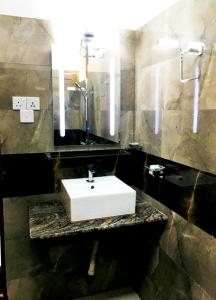 a bathroom with a white sink and a mirror at New Rest House Inn in Mahiyangana