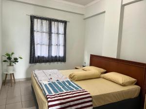 sypialnia z łóżkiem i oknem w obiekcie Lippo carita selatan condo 3bedroom langsung pantai w mieście Carita