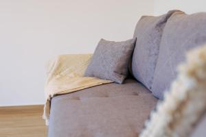 un sofá con dos almohadas encima en Visit Baltic Apartament Łąkowa 20 en Sarbinowo