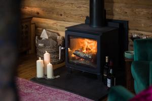 a fireplace with two candles and two bottles of wine at High Kingthorpe Lodge in Levisham +12 photos