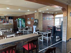 a restaurant with a bar and tables and chairs at Apartmani Ambiente in Plav