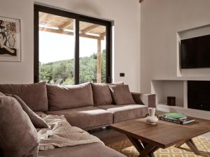 a living room with a couch and a coffee table at Yliessa - Luxury pool villa surrounded by nature in Dhrákas