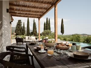 een houten tafel met eten op de patio bij Yliessa - Luxury pool villa surrounded by nature in Dhrákas