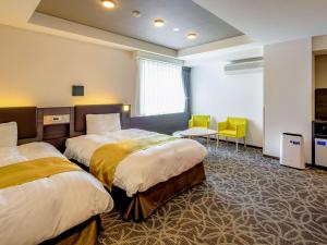 伊勢的住宿－伊勢舒適酒店，酒店客房带两张床和一张桌子以及椅子。