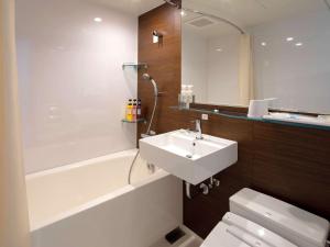 ein Badezimmer mit einem Waschbecken, einem WC und einer Badewanne in der Unterkunft Comfort Hotel Ise in Ise