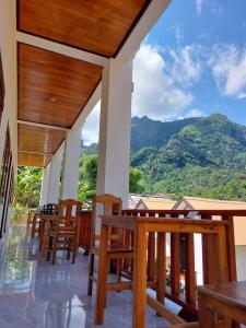 a restaurant with wooden chairs and a view of mountains at Nam ou view villa in Nongkhiaw