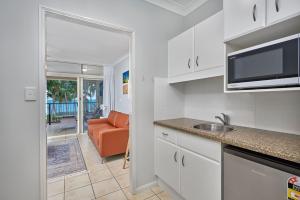 a kitchen with a sink and a microwave at Coral Views at Clifton Beach in Clifton Beach