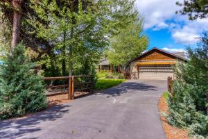 a driveway leading to a house with a fence at Meadow Walk Cabin in La Pine