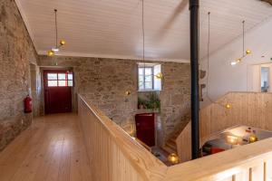 a large room with a stone wall and a staircase at Quinta do Rio Noémi in Guarda