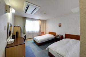 a hotel room with two beds and a television at ホテルスターらんど in Tsuru 