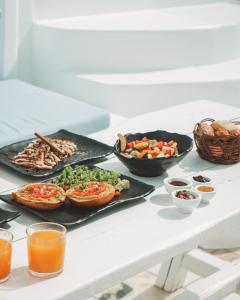 a table topped with plates of food and drinks at Oia Captain's Villa in Oia