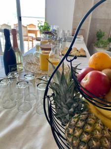 a table with a bowl of fruit and a pineapple at Hotel Buenavista Beach House Trogir in Trogir