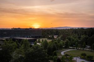 an office building with the sunset in the background at DIWOTEL by Trip Inn Frankfurt Airport Dreieich in Dreieich +61 photos