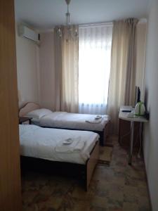 a hotel room with two beds and a window at Tumar Hotel in Aktobe