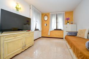 a living room with a large flat screen tv at Prestige Suite Sirmione in Sirmione
