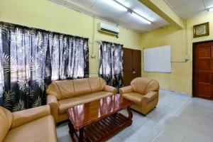 a waiting room with two couches and a table at Super OYO 90509 Usima Forest Resort in Ayer Keroh
