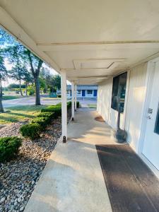 a white building with columns and a walkway at Knights Inn Bridgeport Frankenmuth in Bridgeport