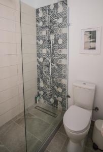 a bathroom with a toilet and a glass shower at Anemomylos guesthouse in Paralimni
