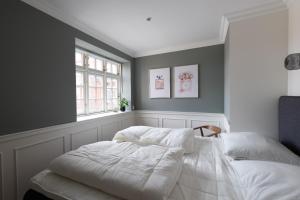 - une chambre avec un lit blanc et une fenêtre dans l'établissement Ankerhus Skagen, à Skagen