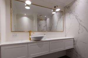 a white bathroom with a sink and a mirror at Ankerhus Skagen in Skagen