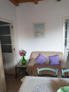 een woonkamer met een bank en een tafel met paarse kussens bij Da Carla in Iglesias