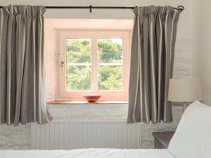 En eller flere senge i et værelse på Oyster Cottage