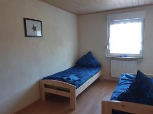 a small bedroom with a bed and a window at Ferienwohnung-Vivienne in Hemfurth-Edersee