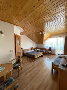 a large room with two beds and a wooden ceiling at ASIA- Pokoje Gościnne i Studia in Ostrowo