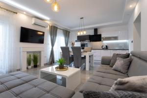 a living room with a couch and a table and a kitchen at VILLA PADRE in Podstrana