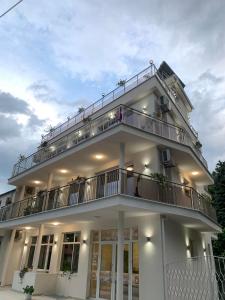 a white building with a balcony with people on it at Villa Perla di Mare in Kranevo