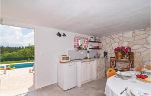 een keuken met een aanrecht, een tafel en een balkon bij Cozy Home In Hrvace With Jacuzzi in Hrvace