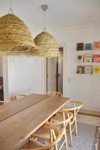 een eetkamer met een houten tafel en stoelen bij Beach house upscale villa with pool in Costa da Caparica