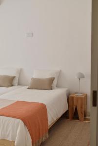 ein Schlafzimmer mit 2 Betten und einer Lampe auf einem Tisch in der Unterkunft Caparica beach upscale villa with pool in Costa da Caparica