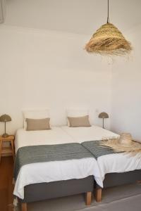 1 Schlafzimmer mit 2 Betten und einem Korb mit Hängen in der Unterkunft Beach house upscale villa with pool in Costa da Caparica