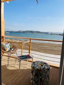 - un balcon avec deux chaises et une table donnant sur l'océan dans l'établissement L’enraguer, à Marseille