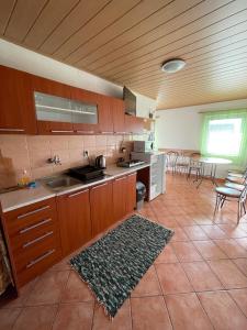 una cocina con armarios de madera y una alfombra en el suelo en Ubytovanie Erika en Vitanová