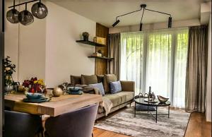 a living room with a couch and a table at Napfény Resort Apartman in Balatonlelle