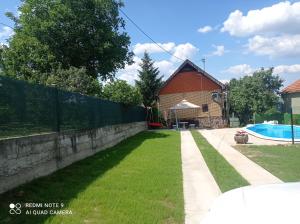 a fence next to a yard with a swimming pool at vikendaja in Rakovac