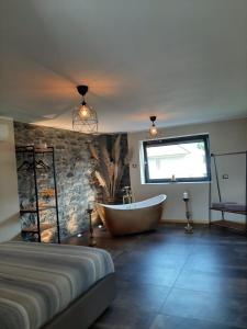 een slaapkamer met een bad, een bed en een raam bij Suite Onorio B&B Zia Vivina in Sorico