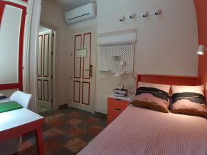 um quarto com uma cama, uma secretária e uma porta em LoopINN Granada em Granada