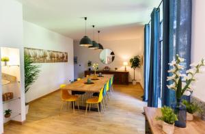 ein Esszimmer mit einem Holztisch und gelben Stühlen in der Unterkunft La Bâtisse de jean in Béziers