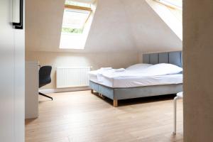 a bedroom with a bed and a chair in a attic at Przystanek Łagów in Łagów