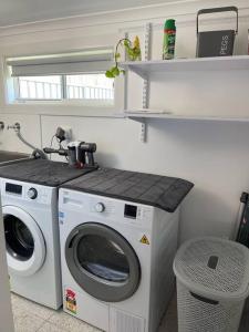 una lavanderia con lavatrice e bancone di Bright, Cosy Cottage near CBD- Free wifi, Netflix and Disney Plus a Orange Altre 22 foto
