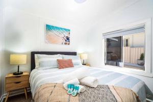 Schlafzimmer mit einem großen Bett und einem Fenster in der Unterkunft Bright, Cosy Cottage near CBD- Free wifi, Netflix and Disney Plus in Orange